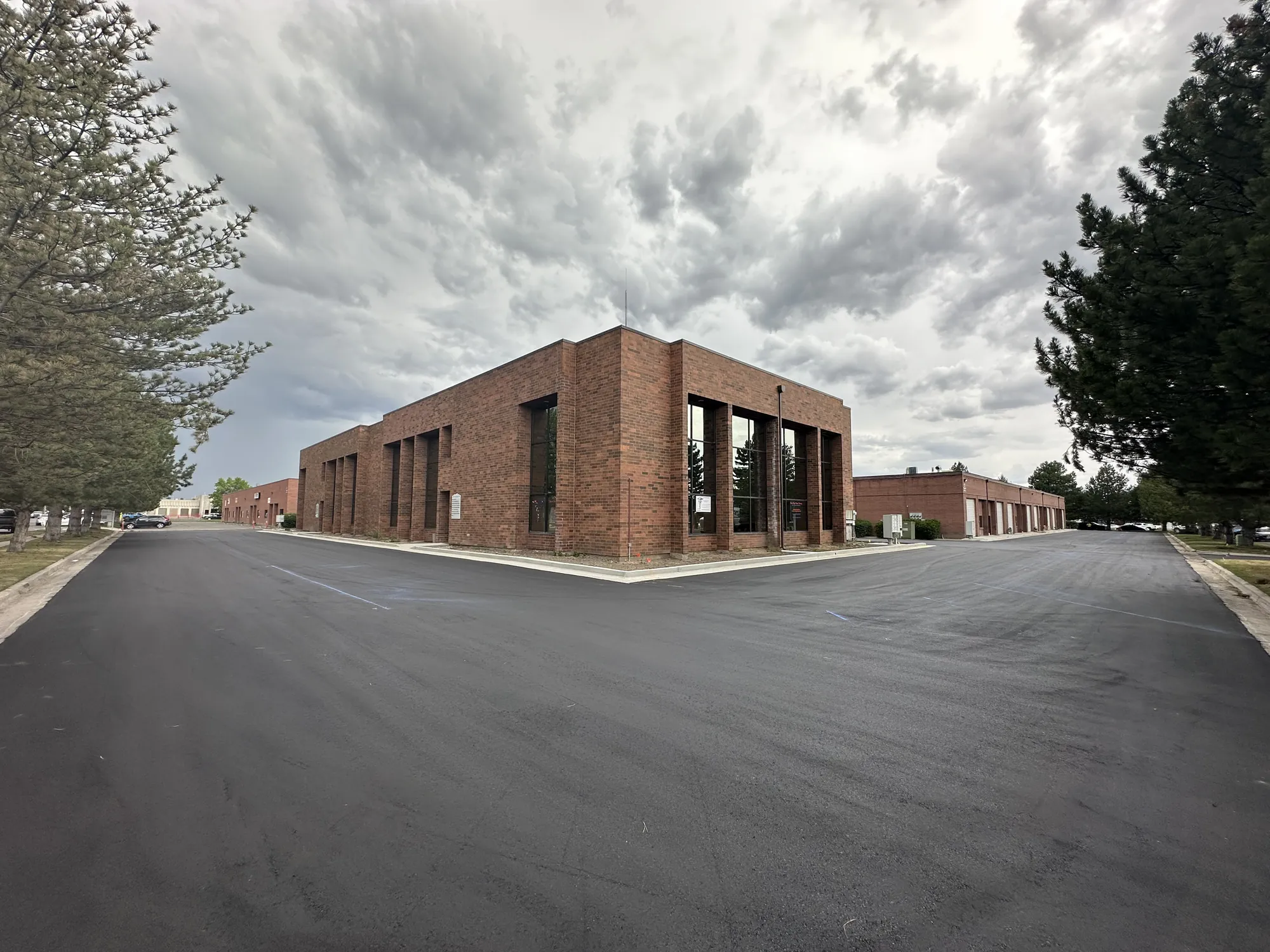 A two-story red brick office building on a freshly paved lot